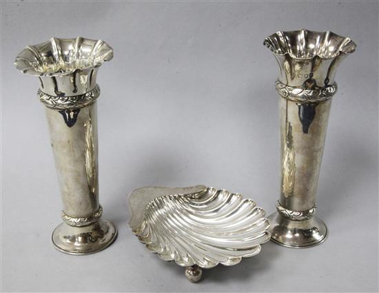 A pair of Edwardian silver spill vases and a silver shell butter dish.